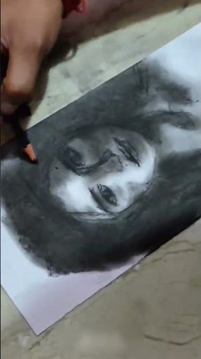 Using charcoal to build tones and textures, shaping the face with light and shadow for realism. #art