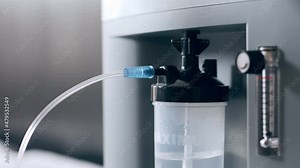 Working oxygen humidifier for nasal cannula, closeup oxygen generator, low oxygen saturation, bubbling water filter. Personal O2 generator for home usage. Oxygen concentrator