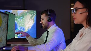 Air traffic controller in headphones talking with the pilot of the plane in air traffic control room