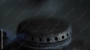 Ignition of a gas burner with a lighter on the stove, close-up. Slow motion