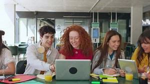 Diverse group of happy high school students studying together on campus. Technology and education lifestyle concept.