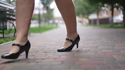 Front view feet of overweight woman stepping on pavement outdoors in...