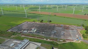 Cinematic Aerial Drone Footage of Keadby Power Plant Substation with Transformers, Powerlines, and Wind Turbines in England Countryside