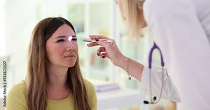 Doctor exams pupils of patient using flashlight in clinic
