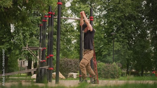 Park Rope Climb Pull Progression With White Male Using Strong Grip On Metal Bars, Focused Upper Body Training, Green Trees In Background, Steady Pace And Intense Pulling Motion For Strength