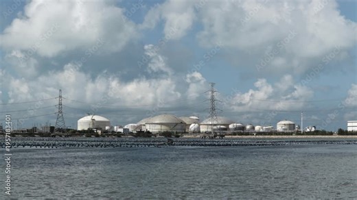 Large petrochemical storage tanks by the sea near Map Ta Phut. Industrial oil and gas storage infrastructure in a coastal refinery complex.