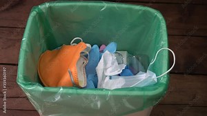Used face masks and gloves throwaway in trash can. Plastic pollution after the COVID-19 pandemic. Disposing medical waste, shoe covers, alcohol wipes, empty plastic bottles of sanitizers