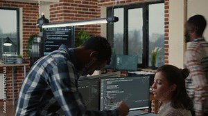 Junior developer sitting down on desk showing laptop with source code to senior dev asking for opinion. Programer writing algorithm interrupted by colleague wanting help with fixing errors.