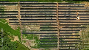 Aerial top down trucking pan of solar farm construction site with rows of solar panels in progress of installation, textured pattern