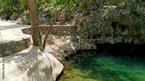 Cenote Park Yaxmuul Yax-Muul with limestone rocks turquoise water.