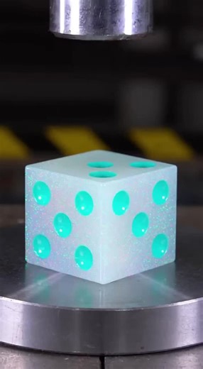 Nic Davis on Instagram: "Watch as a massive opal-finish gaming dice with glitter swirls and glowing pips gets crushed under extreme pressure. The edges crack first, then the whole cube collapses, releasing thick luminous gel from the number cavities in the most satisfying way possible."