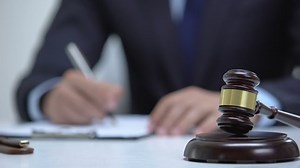 clip-1036588913-gavel-on-block-jurisdictional-symbol-attorney-signing