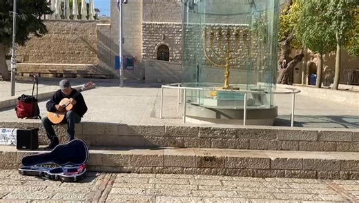 JERUSALEM OF GOLD & THE GOLDEN MENORAH! A brisk, sunny day in December, in the old city of Jerusalem, a man performing Jerusalem of Gold while sitting next to the Golden Menorah constructed by the Temple Institute and ready to be kindled in the Holy Temple, may we rebuild it soon! Days of prophecy! | The Temple Institute