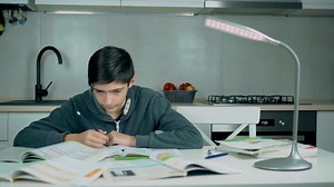 Smart school boy learning writing doing math homework sit at home table. Children doing school homework at home. Self development