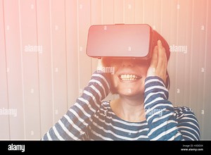 Woman watching 360 video with virtual reality headset. Female using VR goggles to enjoy futuristic multimedia content that simul Stock Photo - Alamy