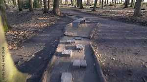 Tactile path for bare feet awakens the senses and uneven endings on the feet alternating different materials wood stone gravel sand bark in a park environment, above, aerial, video, spring, sunny