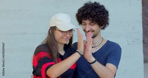 Happy and affectionate couple who are engaged in joyful interaction while being photographed. Heartwarming moment, couple is captured in candid and affectionate pose. Smiles radiating warmth and joy.