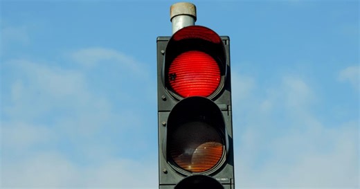 Il grille un feu rouge avec un verre de whisky à la main !