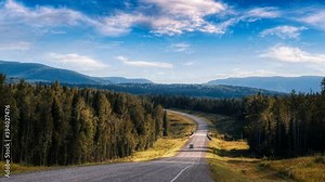 Beautiful View of a scenic road, Alaska Hwy, in the Northern Rockies. Colorful Sunset Sky with Clouds. Taken in British Columbia, Canada. Nature Background Panorama