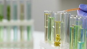 Scientist mixing different fluids to obtain active medication, slow-motion