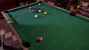 Midwest pool table from the 1970's. A person preparing a shot.