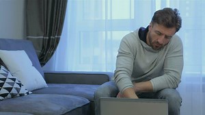 Download Man uses laptop at home for free