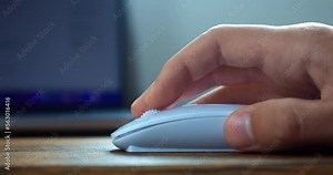 Close up male hand uses white computer mouse, click and scroll the mouse roller, searching for information on the Internet, surfing web pages. Working at computer using handheld pointing device