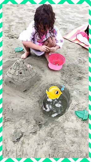 Brincando na praia Laurinha faz um castelinho de areia com piscina 🏰