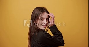 Beauty shy woman smile with beautiful eyes, Arranges hair, makes herself beautiful and looks at camera on isolated yellow Background. Sensual Attractive Woman Model Posing. Cute Natural Woman posing.