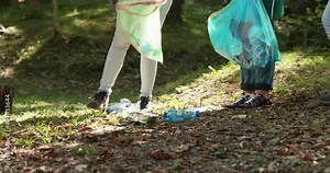 Young cleanup volunteers collecting litter in a forest