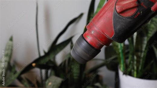 A close up video sequence of a red drill bit spinning, focused on tool operation and household repair concept