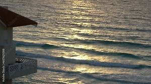 A Cancun senet with sun shining on the water next to a hotel