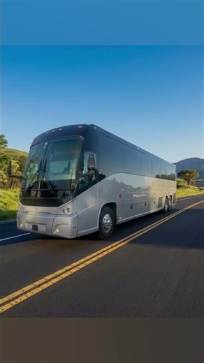 A silver 2018 mci j4500 motor coach bus drive on a nice road in USA