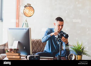 stabilizer camera. computer monitor. Young freelancer man editing video on laptop for uploading video to internet online or social media Stock Photo - Alamy