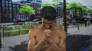 Young hispanic shirtless man clapping hands with a smile on a vibrant sunny street in a cityscape; gratitude.
