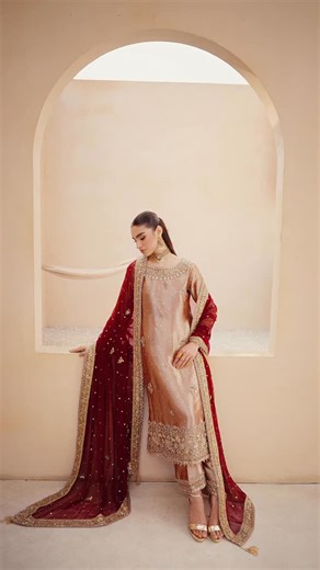 Shujat Ali on Instagram: "Shirt: Pure Tissue Masoori in Champagne Gold. Features a fully embellished boat neckline, heavy zardozi,dabka and sequin work on the cuffs, and scattered motifs across the front. Finished with a detailed scalloped hemline. Dupatta: Premium Chiffon in a deep, rich Red. Heavily embroidered borders on all four sides with gold handwork and scattered sequins with extra motif throughout the center. Trousers: Matching Champagne Gold Pure Tissue Masoori. Wide-leg cut finished w