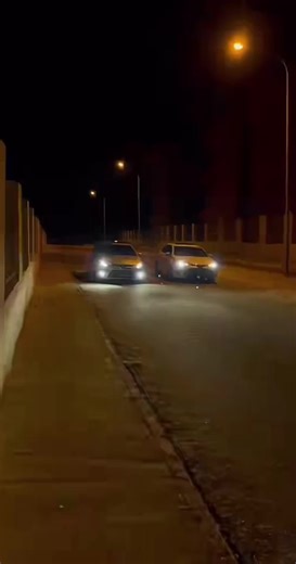 Modern Sedans Driving at Night in Urban Setting