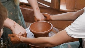 Wheel potter hand clay shaping. Close up hands pottery wheel pot clay potter child craft. Ceramic artist hand pottery wheel pot clay child creative workshop. Mentoring kids art education. Teaching kid Stock Video