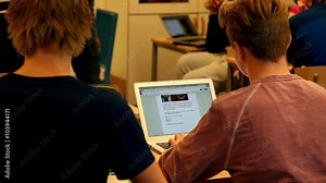 Students Inside a classroom using laptop for studying