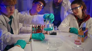 Excited science students with teacher doing chemical experiment in the laboratory at university.