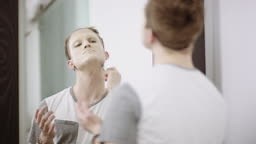 Man applying foundation makeup in order to dress in drag