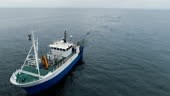 Flying over a Commercial Fishing Ship that Pulls Trawl Net. Shot on...