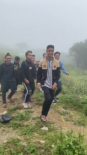 Outdoor Group Hiking Adventure in Foggy Fields