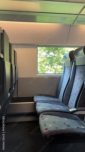 Carriage interior of modern high speed passenger train with empty seats, chairs. Window. Vertical 4K video. Train station. Railway. Concept of transportation, tourism, travel, trip, arrival, departure