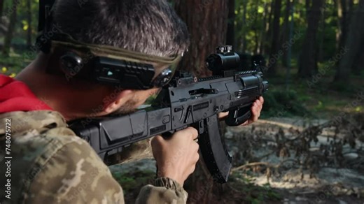 Scope Adjusted, Camouflaged Soldier, focused soldier. Focused Laser tag soldier in camouflage attire takes aim with modern rifle in dense woodland setting, highlighting military precision