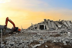 Excavator with hydraulic breaker hammer for the destruction of concrete and hard rock. Jackhammer demolition the old building. Recycling of construction waste at the construction site Stock Photo