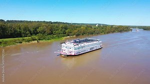 Beautiful aerial shot of a paddlewheel steamboat luxury cruise ship on the Mississippi River.