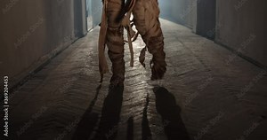 Scary Egyptian mummy creeping down hallway in abandoned cursed house. Creepy ancient zombie walking with clumsy moves - halloween costume 4k footage