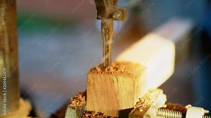 Geared head drill press slow motion on wood industry on blurred background. It is a geared head drill press is a drill press in which power transmission from the motor to the spindle to hole on wood