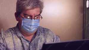 Remote teacher man in a mask online chat with a student. On a laptop computer, an online conference on a webcam chat. Distance education, virtual learning and business concept.